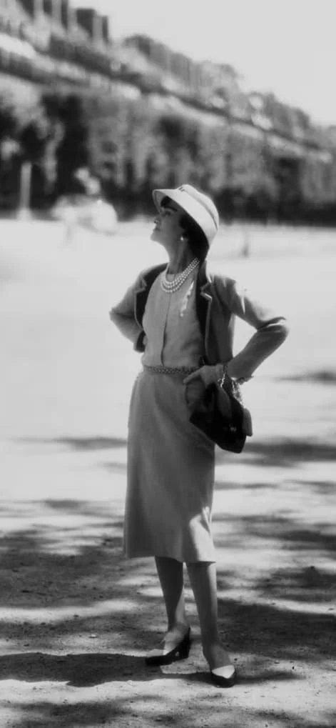 Gabrielle Chanel 身穿软呢套装、肩背链条包大步走路的历史照片