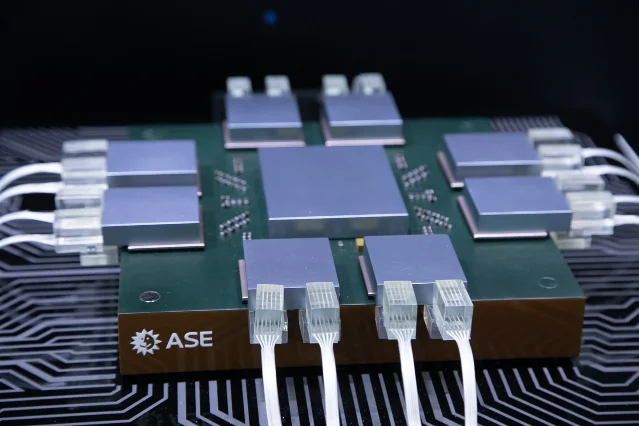 ASE advanced packaging sample: a multi-chip module with central large die surrounded by eight smaller dies on a green substrate. Source: Digitimes