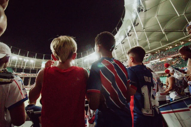 Soccer fans packed into a stadium at night, scarves raised, floodlights blazing — the kind of crowd the 2026 World Cup will bring to American cities this summer