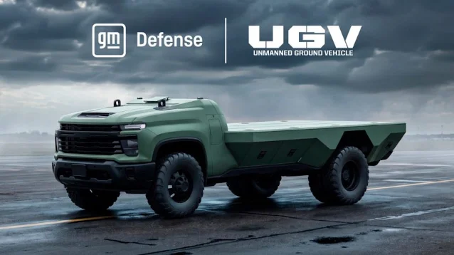A green GM Defense Unmanned Ground Vehicle, a Silverado-based truck with a low flatbed body, parked on a wet runway under a cloudy sky