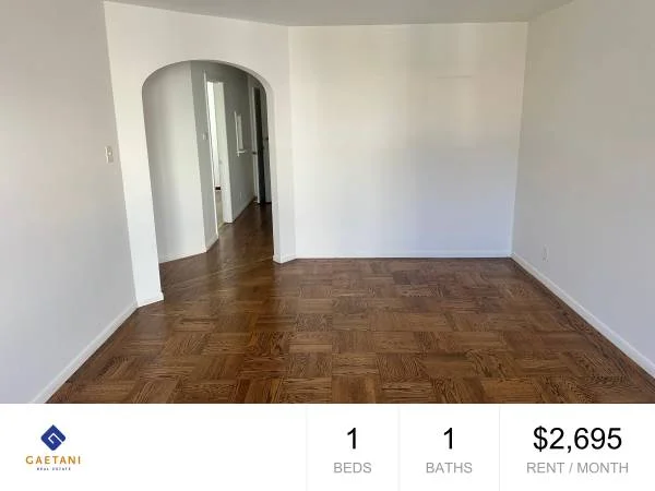 Living room at 1571 Revere Ave #1 — arched doorway and parquet hardwood floors, Gaetani Real Estate listing