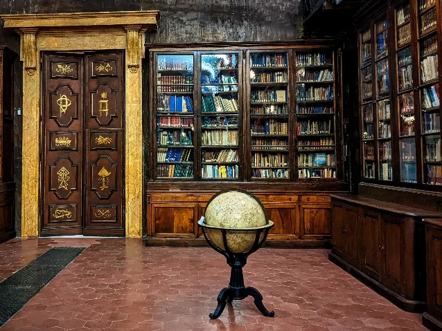 A historic library in Florence with wooden bookshelves and a vintage globe, representing Renaissance humanist book culture