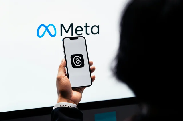 Hands holding smartphone with Meta Threads and Meta branding