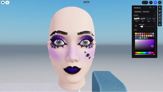 The in-experience makeup panel, showing brush presets and a colour picker beside a bare avatar head wearing purple eye makeup