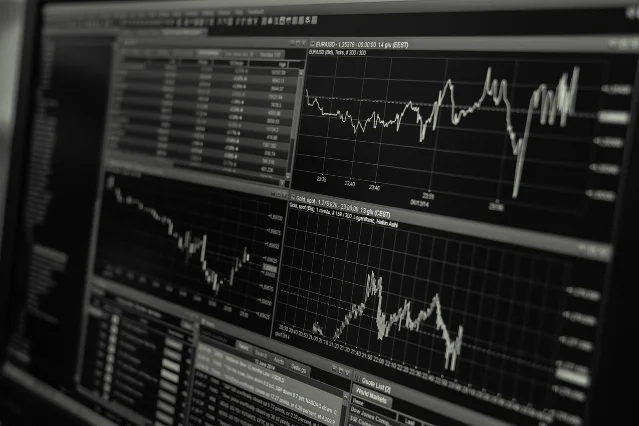 Stock market trading data on multiple monitors — multi-variable tracking mirrors the AI performance grid