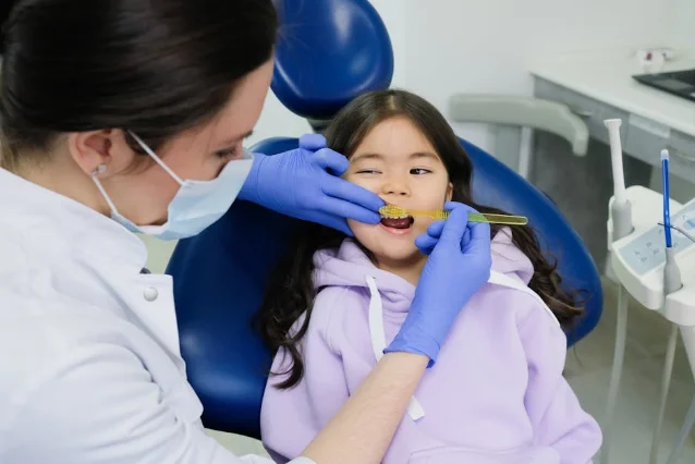 Female dentist examining a young girl's teeth in a modern dental clinic