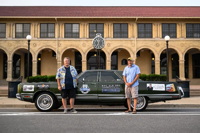 Two men standing beside a 1973 Chrysler New Yorker on the Route 66 centennial trip