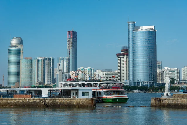 Xiamen skyline with the island city's towers reflecting in the water at dusk