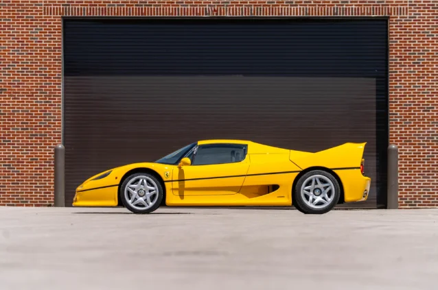 Yellow Ferrari F50 outside a brick building