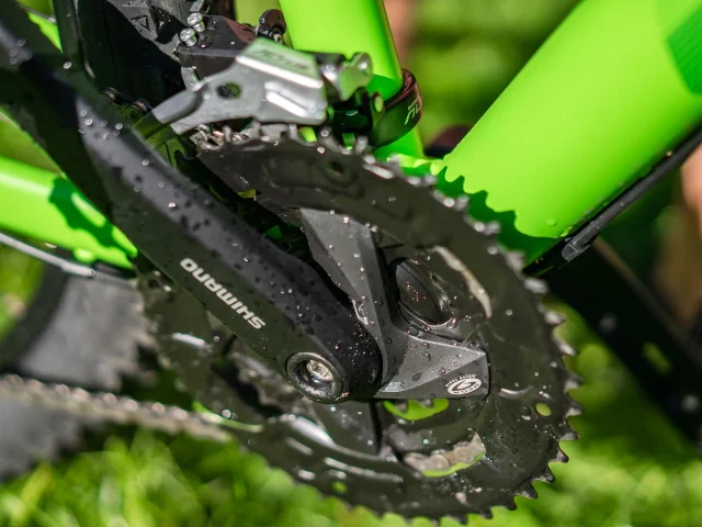Bicycle crankset close-up showing the bottom bracket area where pedal-assist sensors are mounted