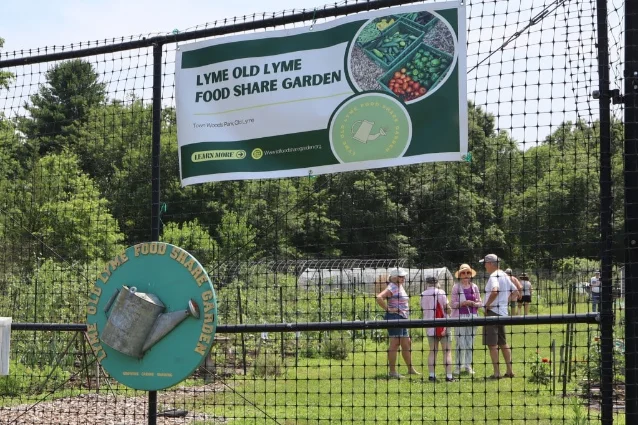 The Lyme Old Lyme Food Share Garden sign hangs on a fence