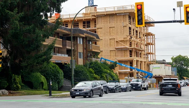 Construction site with workers building affordable housing in a small city setting