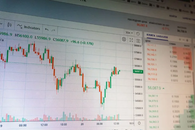 Digital cryptocurrency trading chart with red and green candlesticks on dark screen
