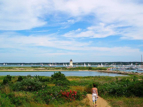 Edgartown Lighthouse on Martha's Vineyard with a rocky shoreline and blue sky