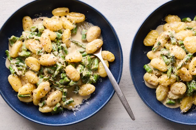 Two deep blue bowls of creamy lemon asparagus gnocchi