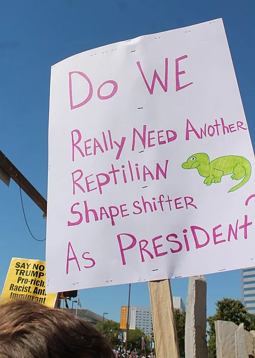 A protest sign referencing the reptilian conspiracy theory, circa 2010s