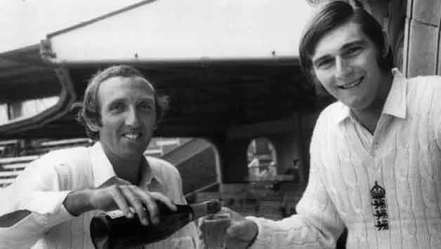Geoff Arnold (left) pours champagne for Chris Old after the match — Old took 5-21, Arnold 4-19 as India were dismissed for 42