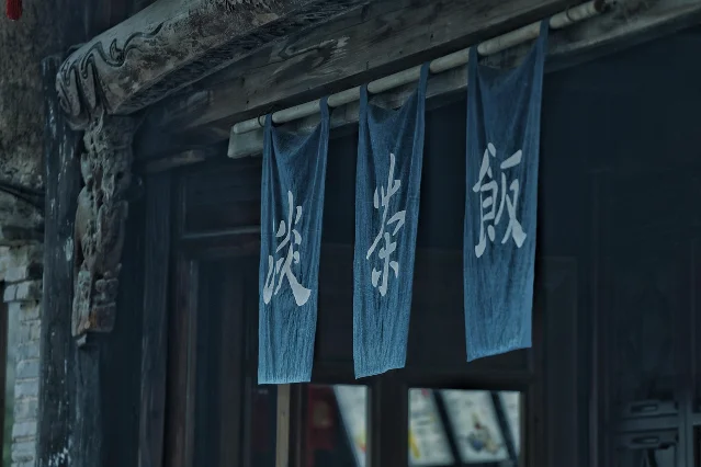 江南水乡古镇夜景，传统建筑倒影在水面，灯笼昏黄，烟火气浓