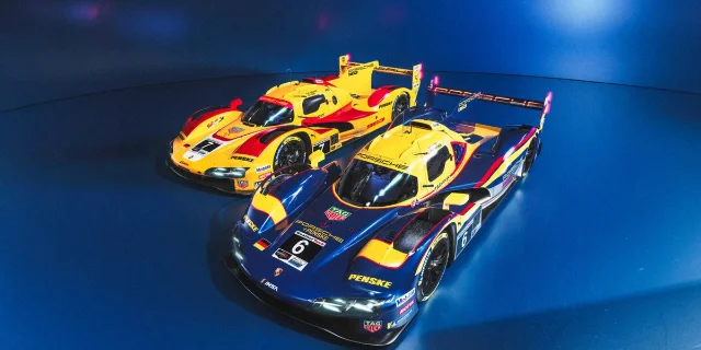 Two Porsche Penske 963 race cars in throwback blue, yellow, and red liveries