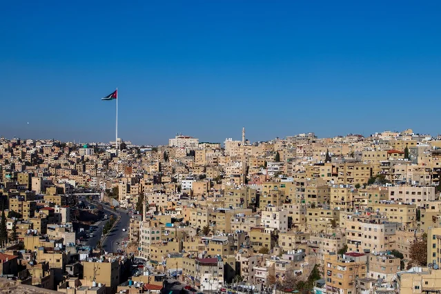 Amman cityscape with Jordanian flag flying over the city