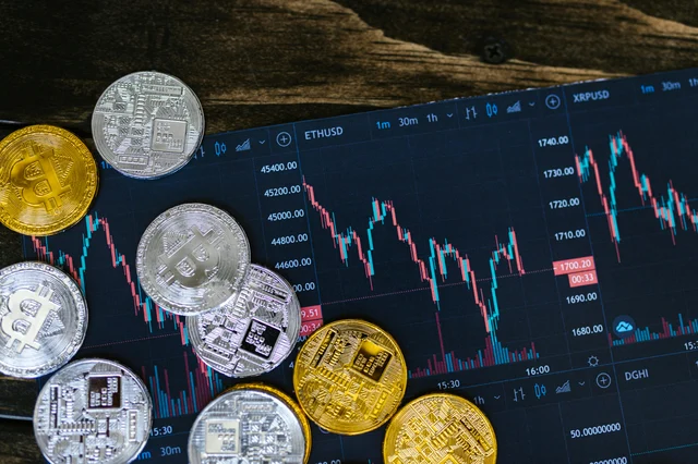 Gold and silver cryptocurrency coins on a digital trading chart