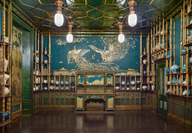 The south wall mural Art and Money: two fighting peacocks in gold and silver on Prussian blue