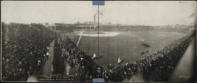 A wide black-and-white photograph of a baseball park seen from high in the grandstand, with a dense crowd packing the double-decked stands and thousands more standing on the outfield grass behind the fielders.
