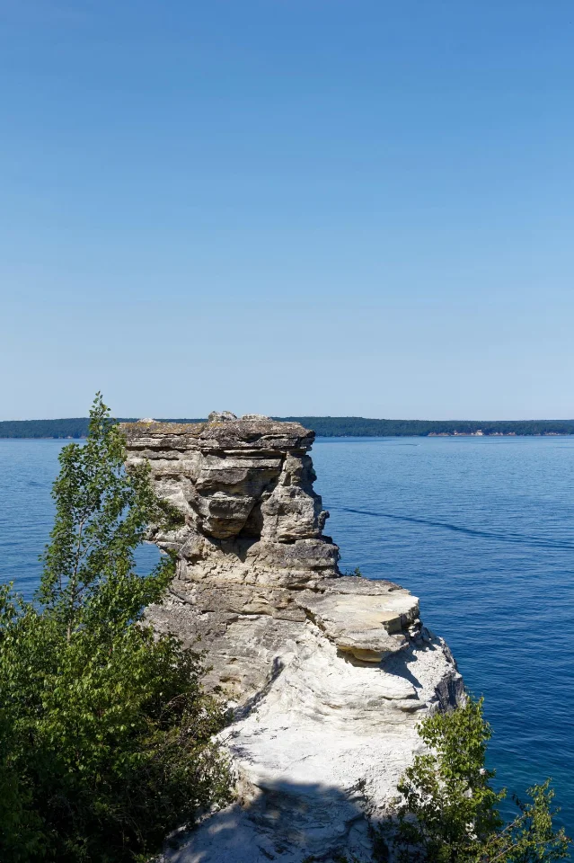 Miners Castle sandstone formation rising above the turquoise blue water of Lake Superior at Pictured Rocks