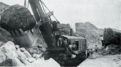 A Marion Model 90 steam shovel working a section of the Panama Canal excavation, 1908 — the shovel's dipper stick and bucket are visible against the cut face, with workers at the base for scale