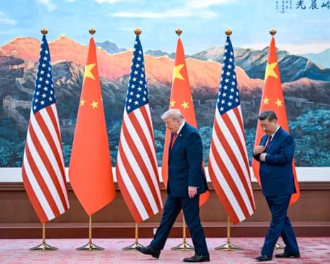 习近平与特朗普走过舞台,背景为中美两国国旗交替排列