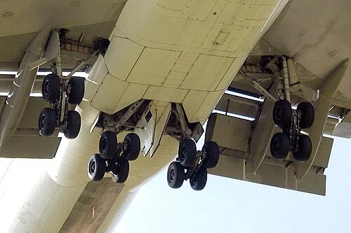 The 747's four main landing gear bogies, each with four wheels, viewed from below during approach