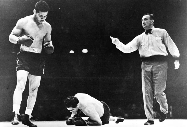 Joe Louis standing over a fallen Max Schmeling on the canvas, referee gesturing toward Louis, 1938 Yankee Stadium