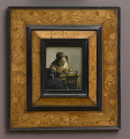 The Lacemaker in its ornately carved frame — the panel is just 24 × 21 cm, nearly dwarfed by the gilt surround