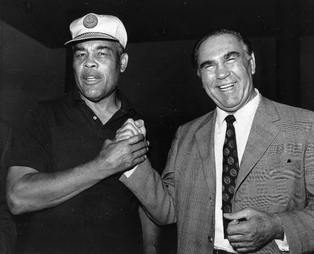 Joe Louis and Max Schmeling shaking hands and smiling, photographed together in 1971