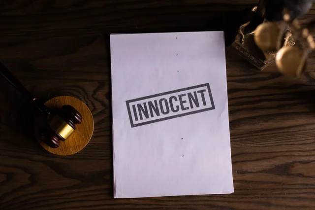 Legal document stamped INNOCENT beside a gavel (Katrin Bolovtsova / Pexels)