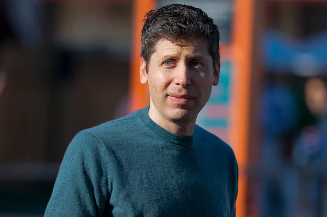 Sam Altman 穿深绿色毛衣,在户外拍摄,背景是虚化的橙色与蓝色