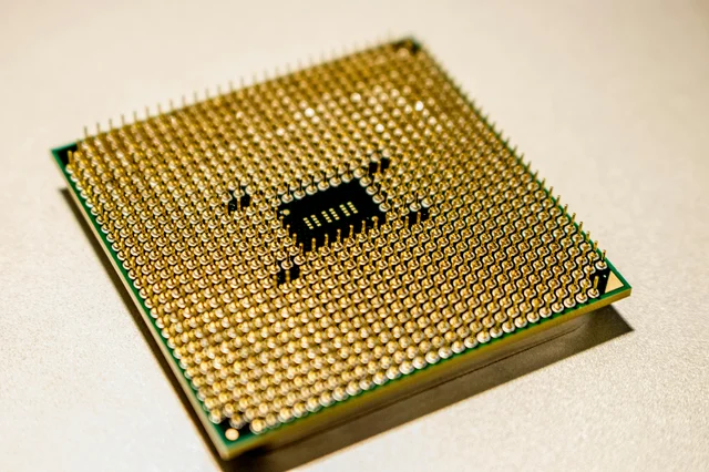 Close-up of a golden microprocessor chip against a white background