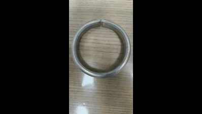 Silver-coated gold kada (traditional Indian solid bangle) sitting on a desk — the exterior looks unremarkable; interior is 24-karat gold