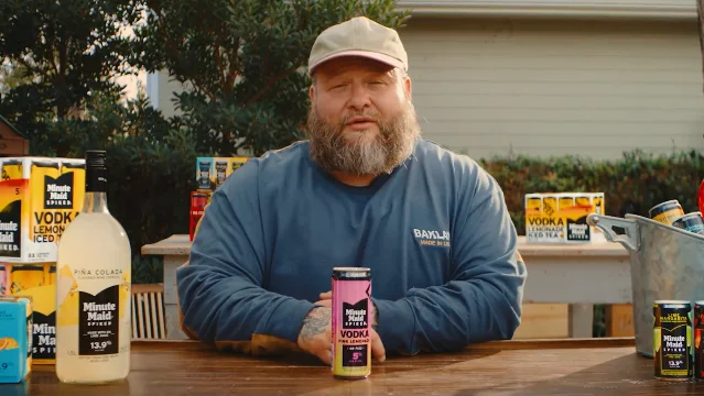 Action Bronson 坐在桌前展示 Minute Maid Spiked 饮品