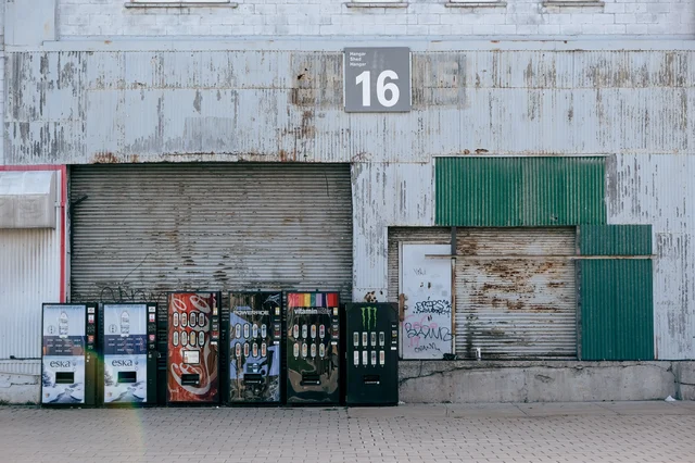 Row of vending machines outside a warehouse loading dock — the kind of industrial placement that drives S-tier returns