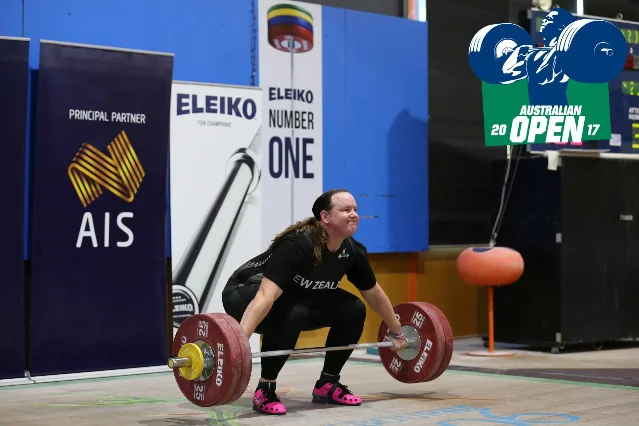Laurel Hubbard in New Zealand singlet at the 2017 Australian Open, gripping the barbell at the start of a snatch attempt, AIS and Eleiko branding behind her