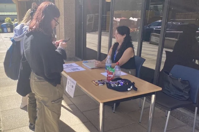 University of St Andrews hallway usability test, September 2023: students stopping to test the university website at a table outside the library, guided by a member of the Digital Communications team