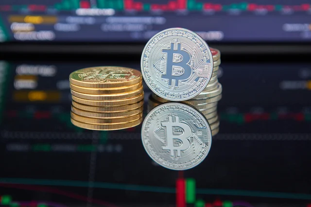 Bitcoin coins stacked in front of a cryptocurrency trading chart