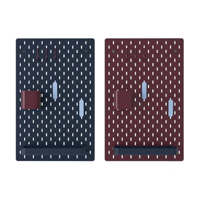 SKÅDIS double-sided pegboard showing both sides — dark grey-blue and dark lilac-red panels each fitted with hooks and a storage cup