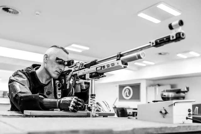 Air rifle shooter in precision stance, black and white photograph