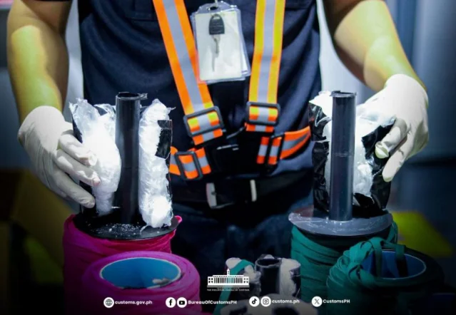 A customs officer holding opened rope spools containing suspected shabu packets