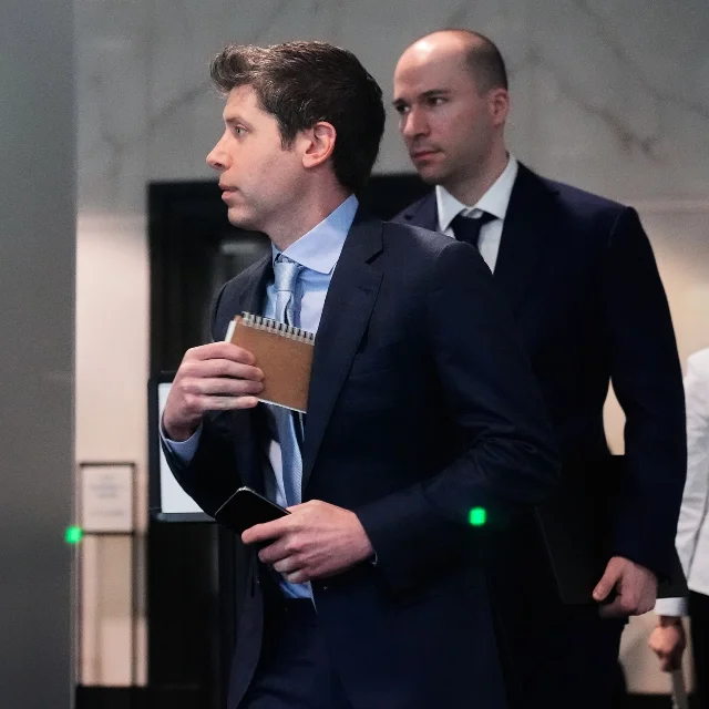 Sam Altman 与 Greg Brockman 并肩行走,来自美联社,刊登于 WIRED 报道