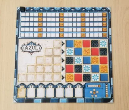 Azul 玩家面板实物照:左侧为 5 行预备区,右侧为 5×5 彩色瓷砖墙,底部为废砖计分槽