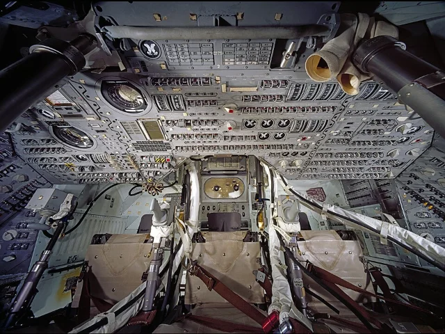 Columbia's interior crew compartment viewed from outside through the main window — dense instrument panel and three crew stations visible (NASM2013-02663)