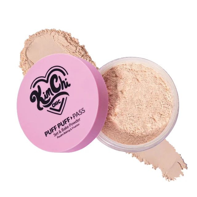 KimChi Chic Beauty Puff Puff Pass Set &amp; Bake Powder — open jar showing finely milled beige setting powder with the pink lid propped beside it and a swatch below. Drag queen Kim Chi's indie brand, on sale $15 during DFYD. Via kimchichicbeauty.com.